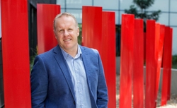 A laboratory worker at Pharmaxo Scientific prepares a pharmaceutical product