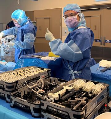 Dr Cameron Cooke in action using the new Velys robot system, helped by an orthopaedic scrub nurse